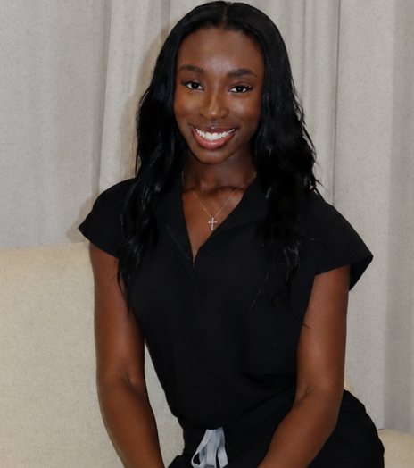 Nia B., founder of Eden Aesthetics, smiling in the studio